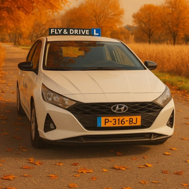Witte Hyundai sedan met een waarschuwingsbord voor beginnende bestuurders geparkeerd op een herfstweg bedekt met gevallen oranje bladeren.