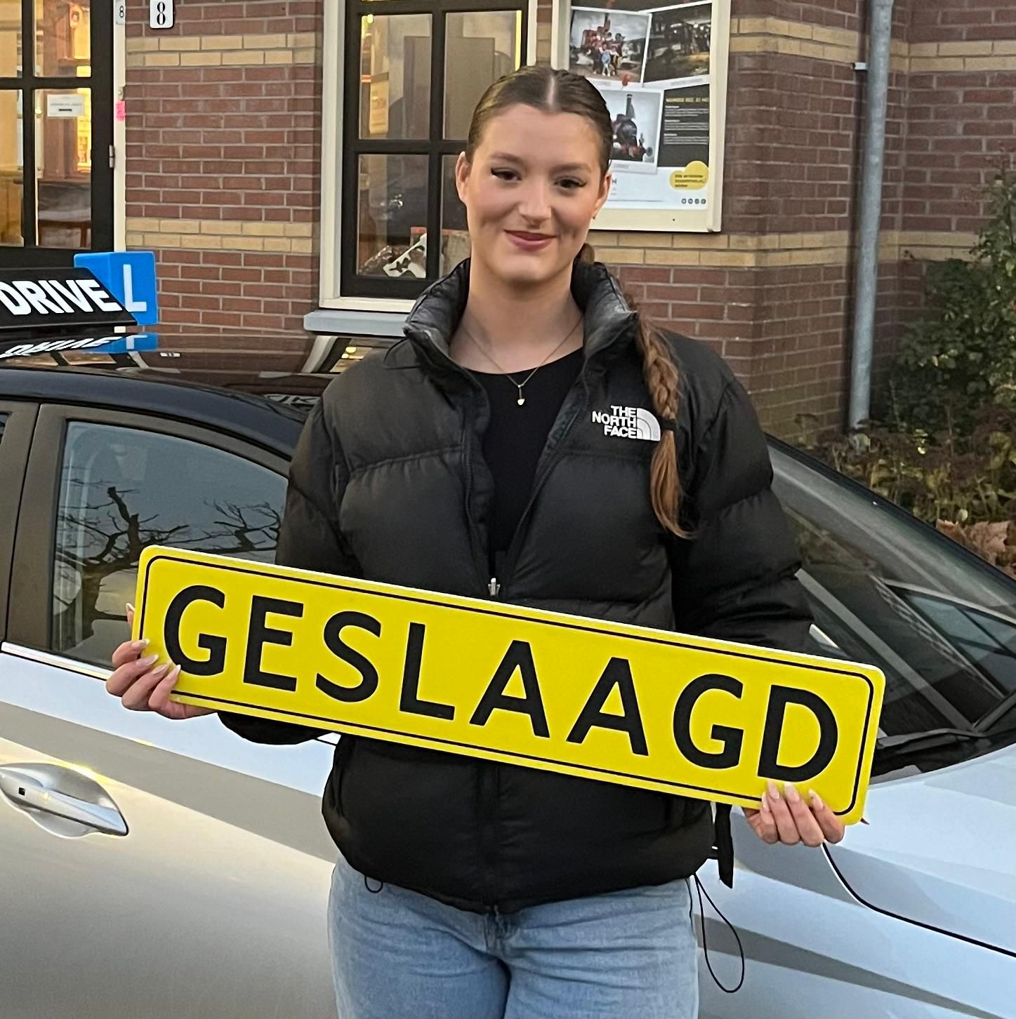 Vrouw lachend voor een auto, met een geel