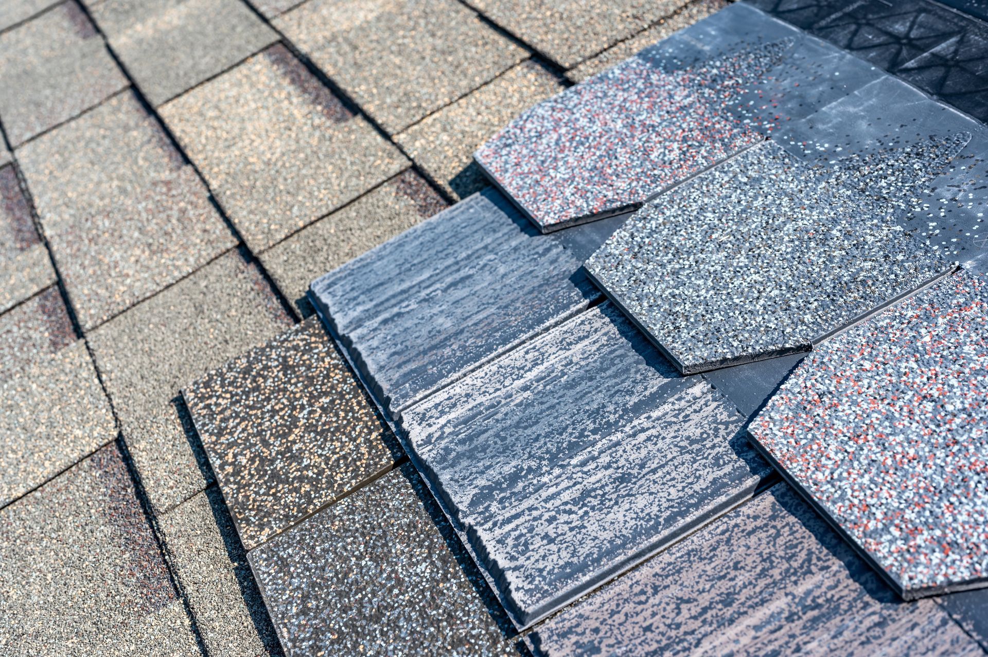 Damaged asphalt shingle roof with a patch of replaced shingles in gray and speckled colors