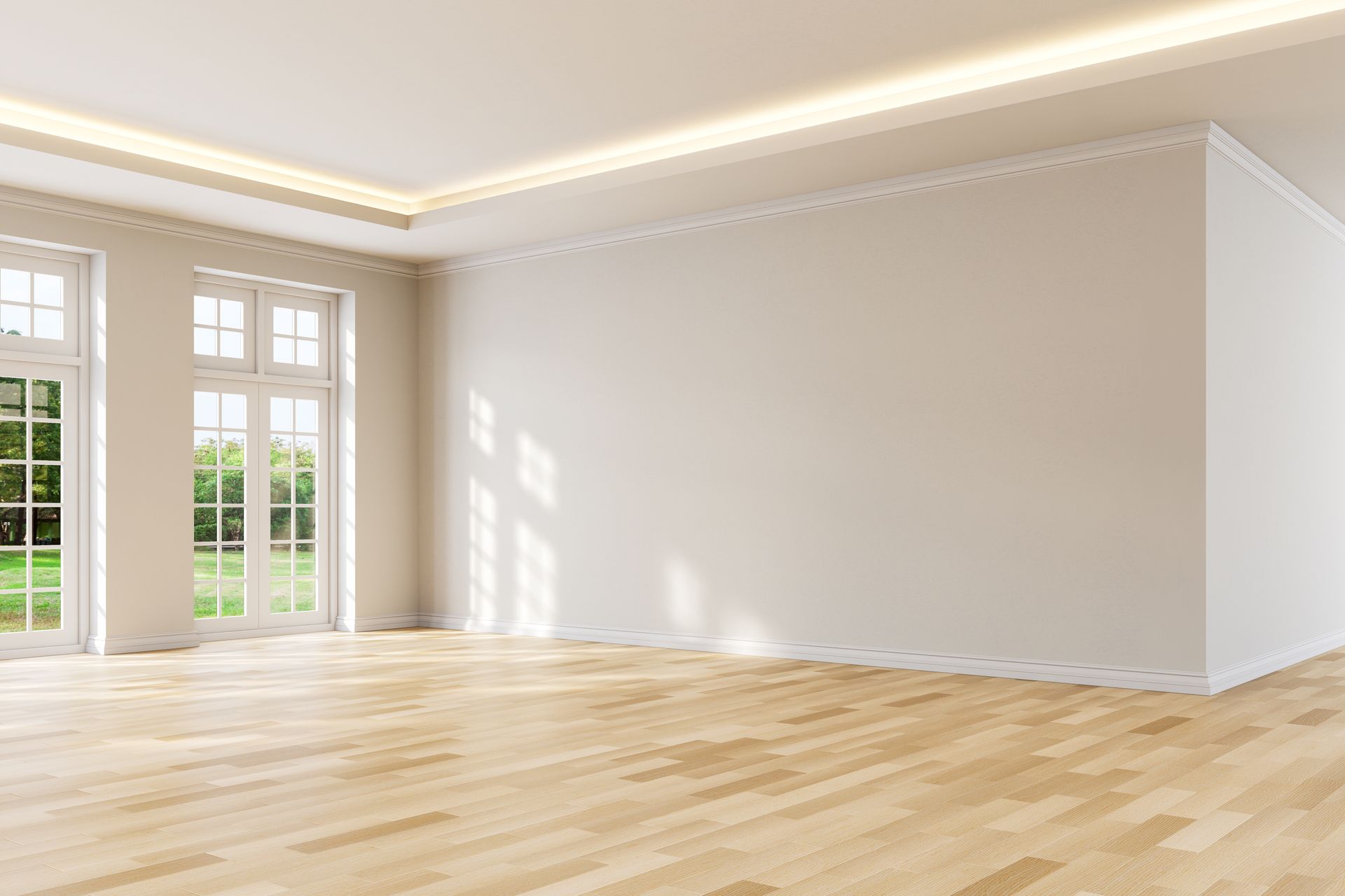 Empty bright room with light wood floors, white walls, and tall windows letting in sunlight