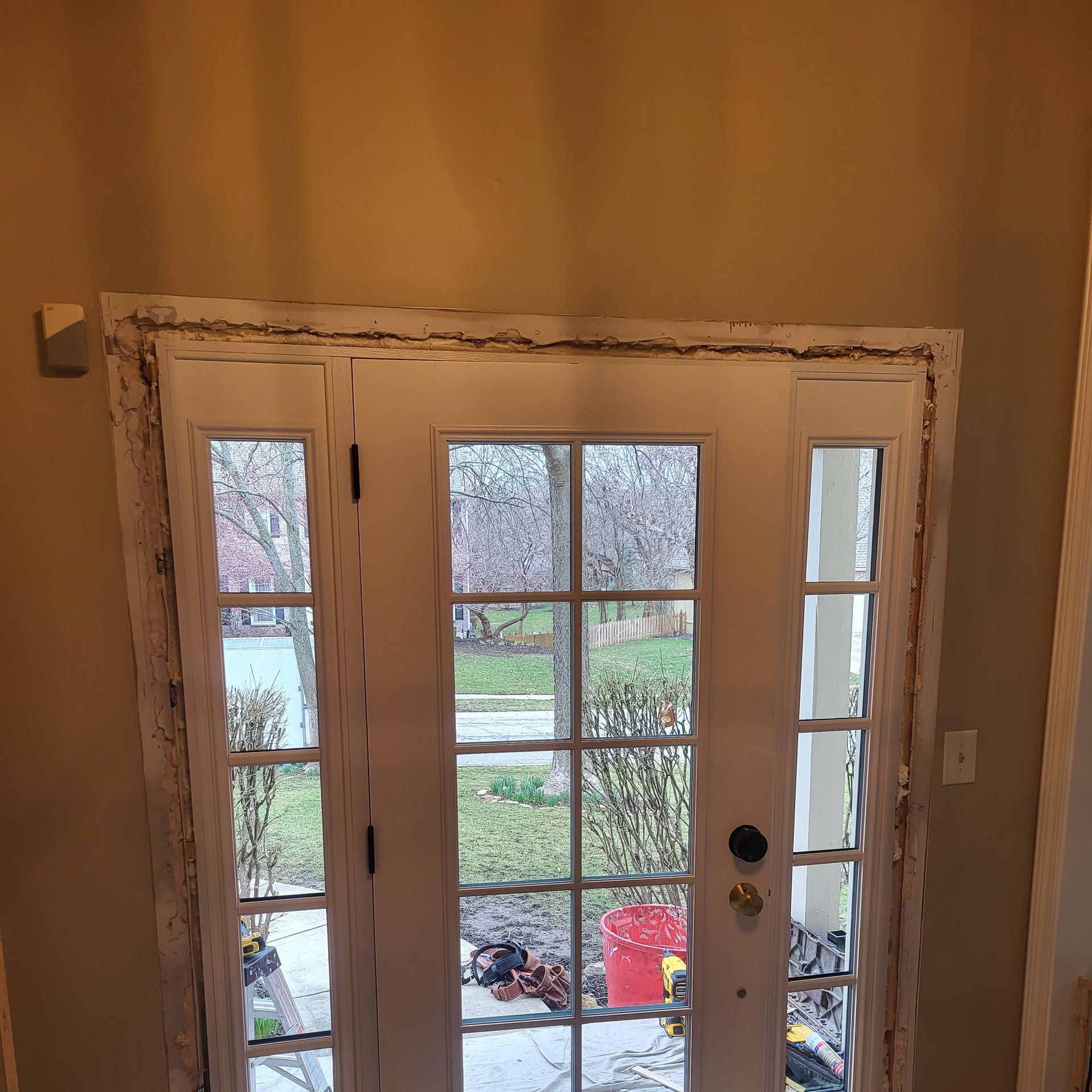 A door with a view of a garden is being remodeled.