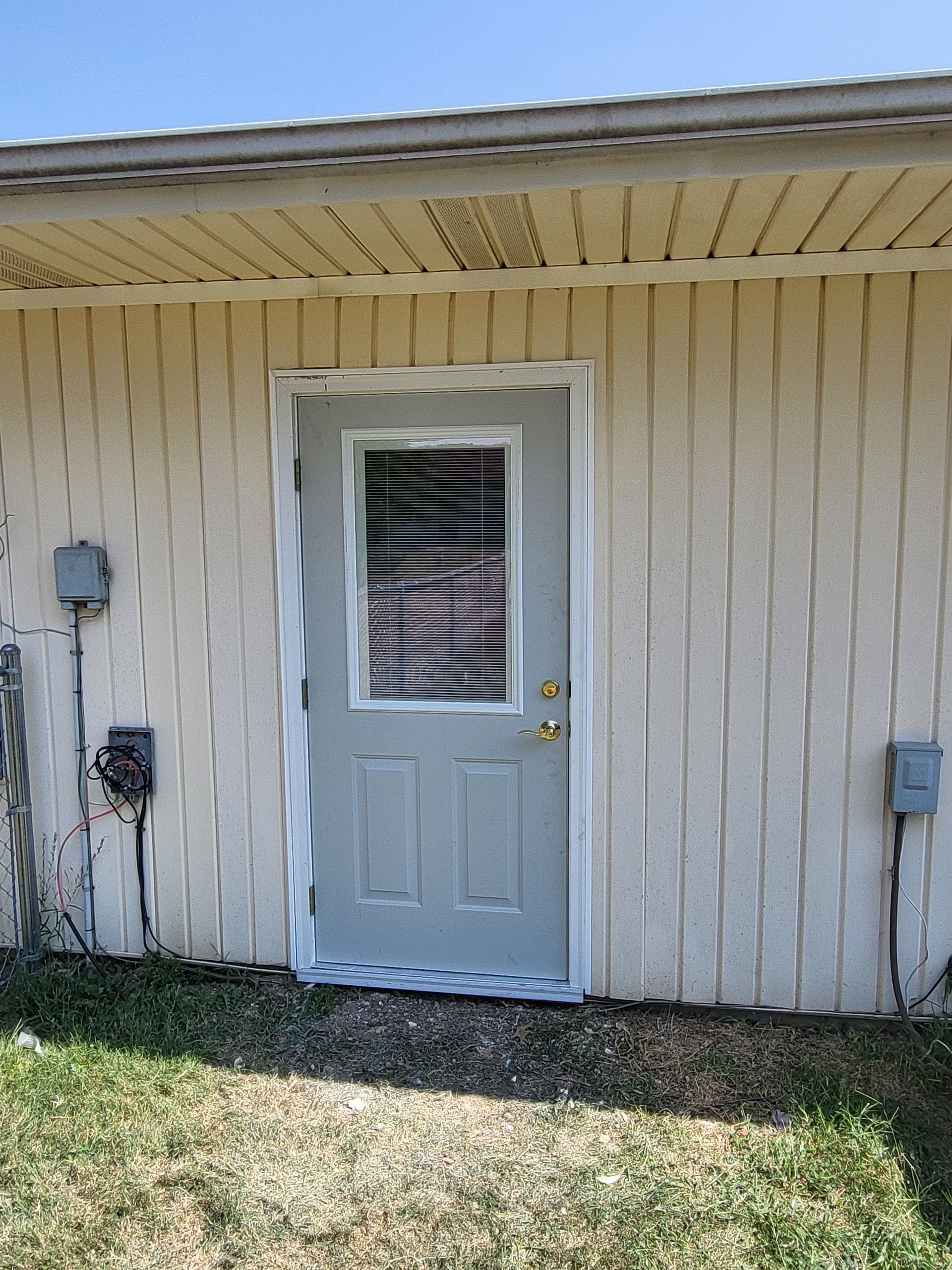 A white house with a gray door and a window.