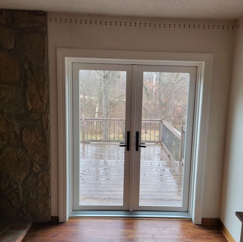 An empty room with a sliding glass door leading to a deck.