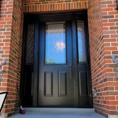 The front door of a brick house with a black door