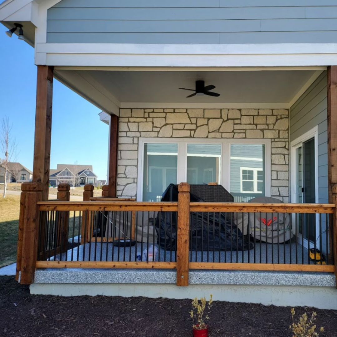 A porch with a grill and a ceiling fan