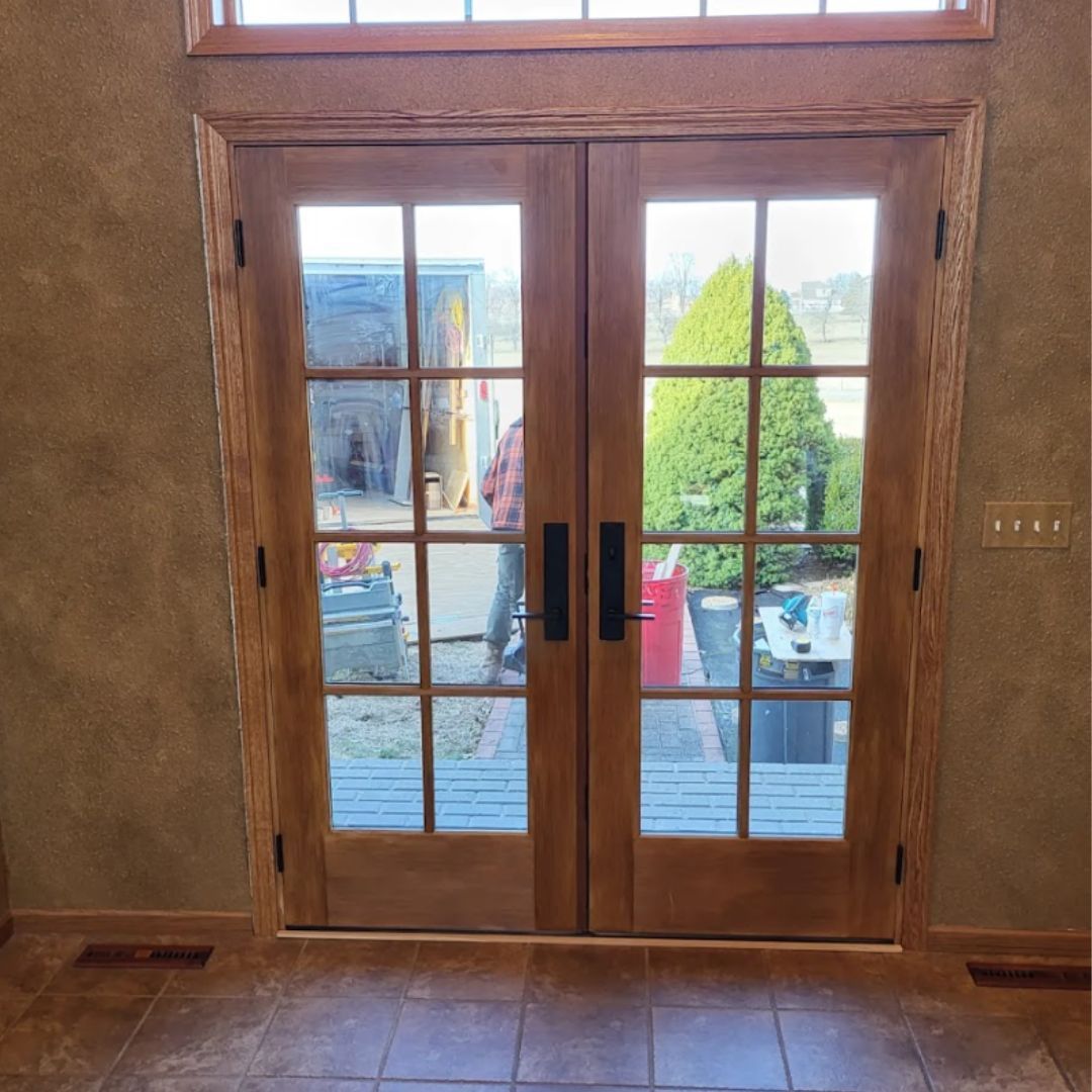 A man is standing in front of a glass door