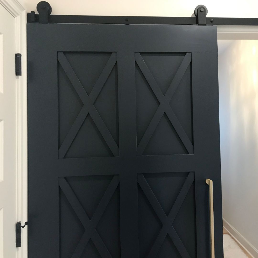 A row of white cabinets with black handles.