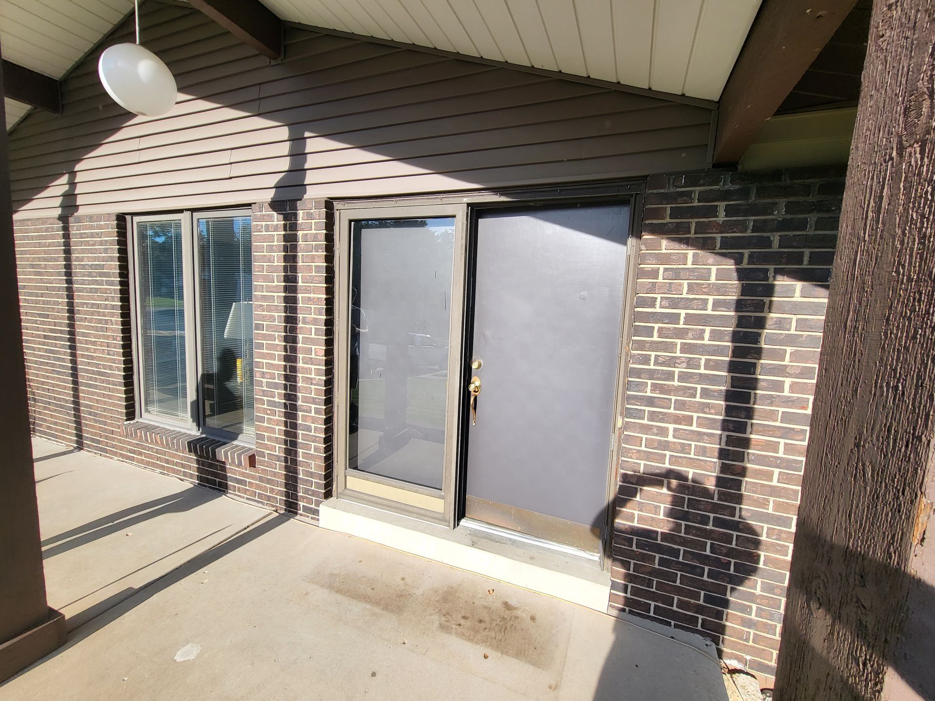 A brick building with a patio and sliding glass doors