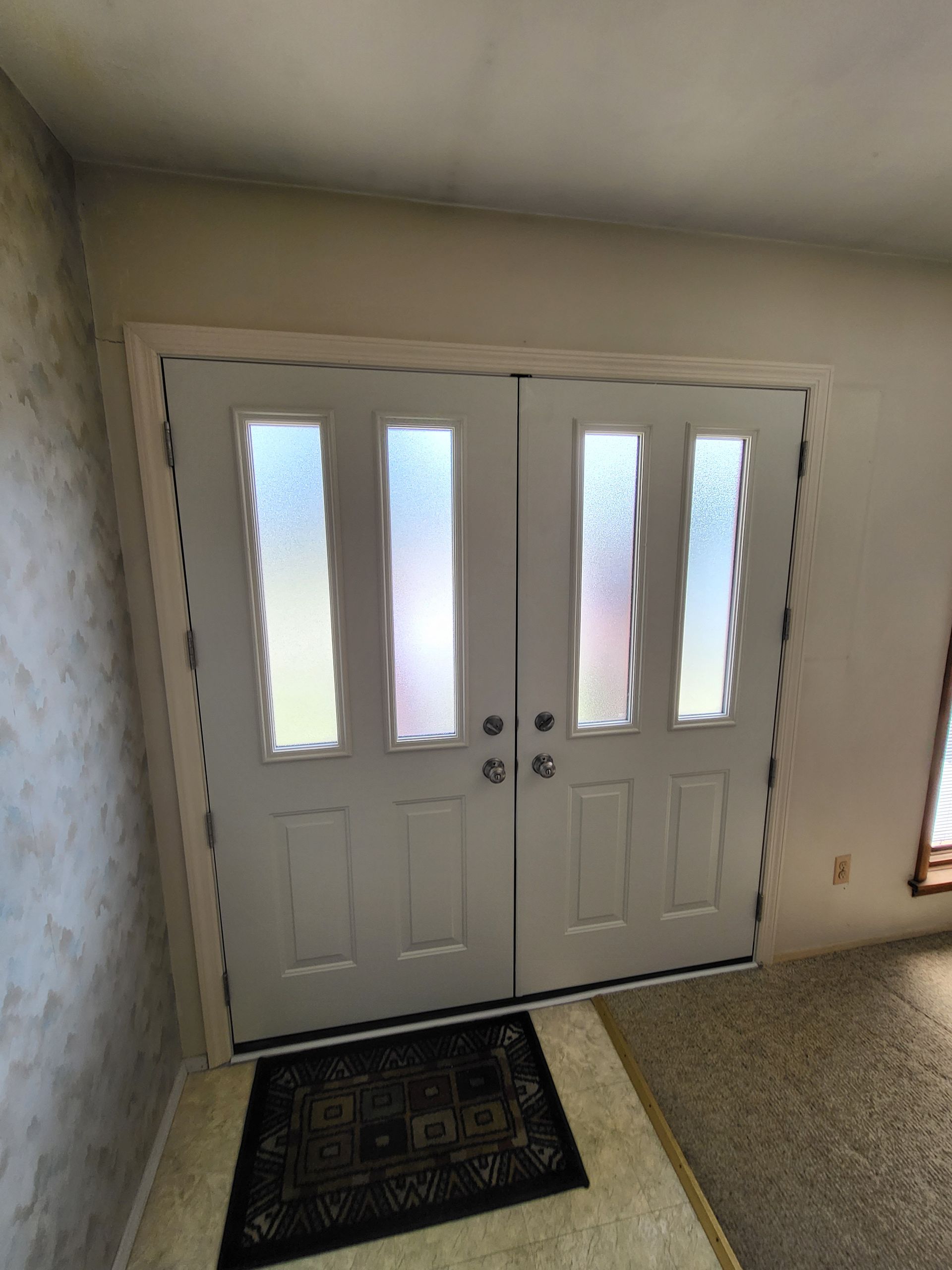 A pair of white double doors with frosted glass in a living room.