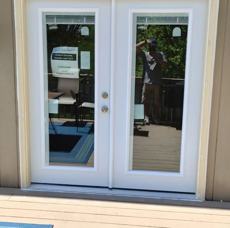 A man is standing in front of a glass door
