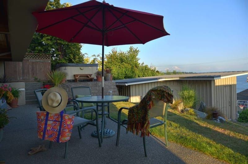A red umbrella is sitting on a patio next to a table and chairs