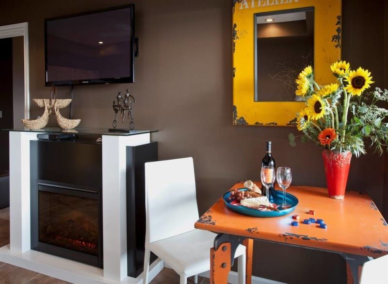A living room with a table and chairs and a fireplace