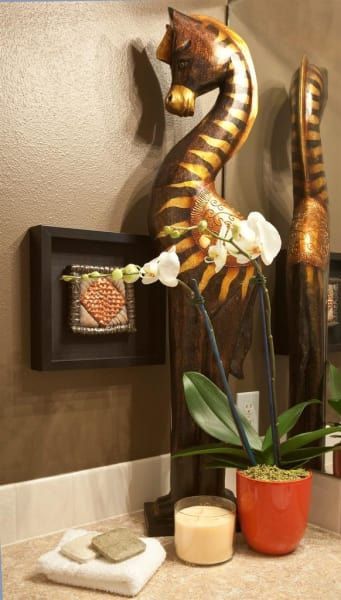 A bathroom counter with a statue of a horse and a potted plant