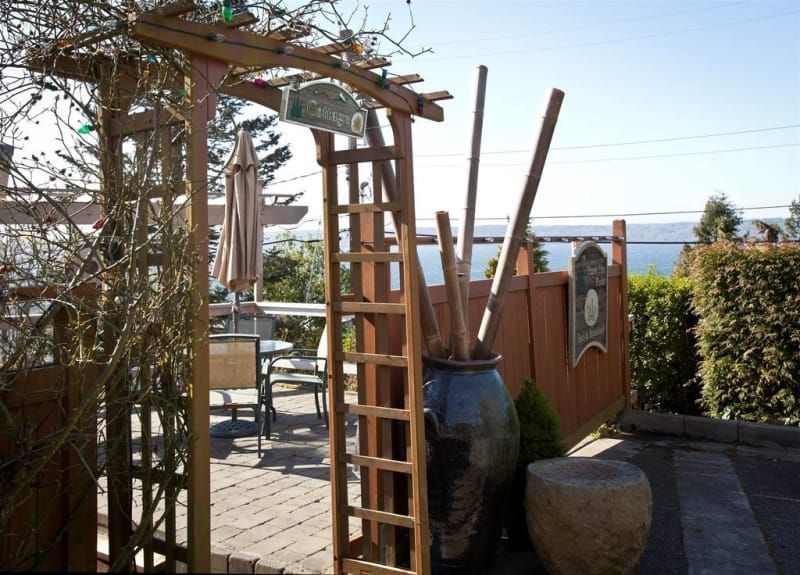 A wooden archway leads to a patio area