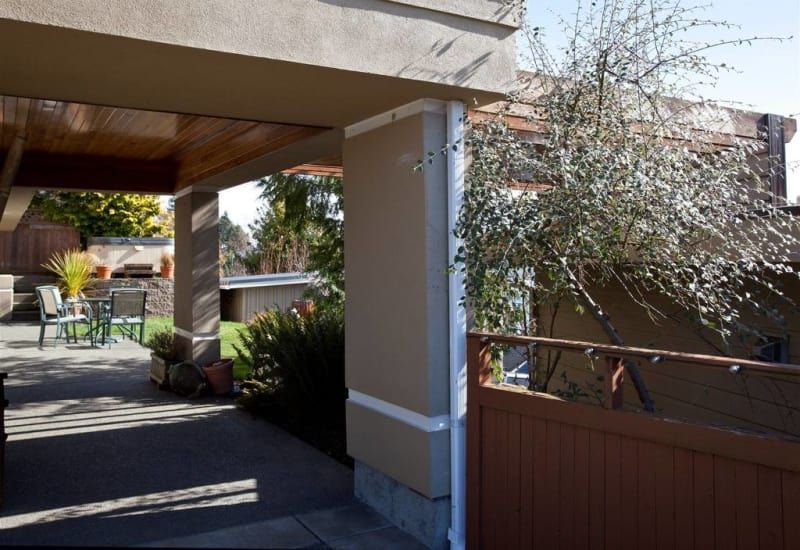 A house with a covered patio and a wooden fence