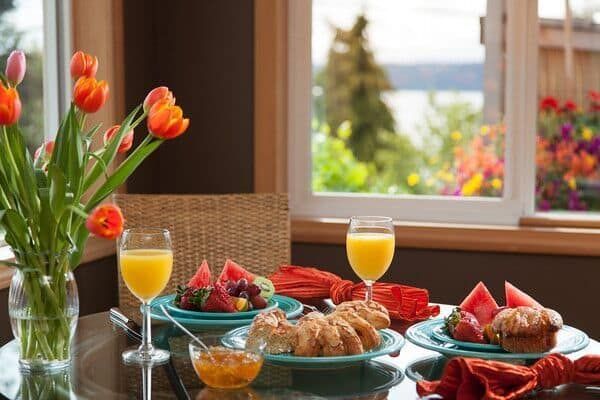 A table with plates of food and glasses of orange juice