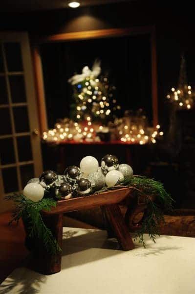 A table with christmas decorations and a christmas tree in the background