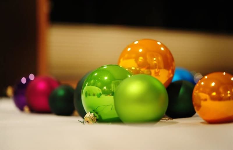 A bunch of colorful christmas ornaments are sitting on a table.