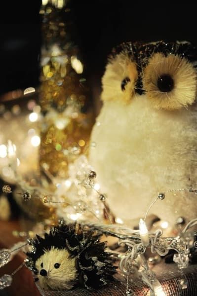 A stuffed owl is sitting next to a stuffed hedgehog.