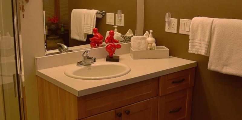 A bathroom with a sink , mirror , and towels.