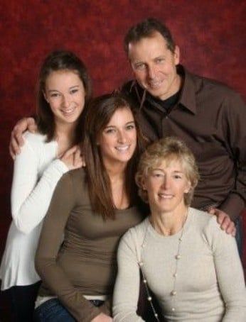 A family posing for a picture with a red background