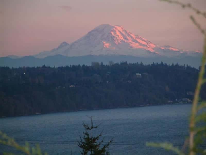 A mountain covered in snow is visible over a body of water.