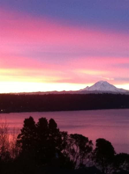 A sunset over a lake with a mountain in the background