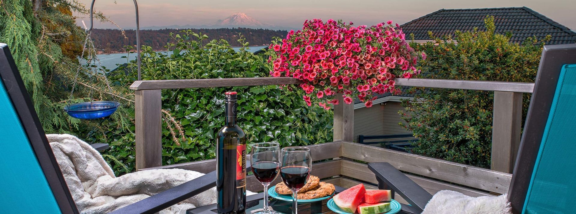 There is a table with a bottle of wine and two glasses of wine on it.