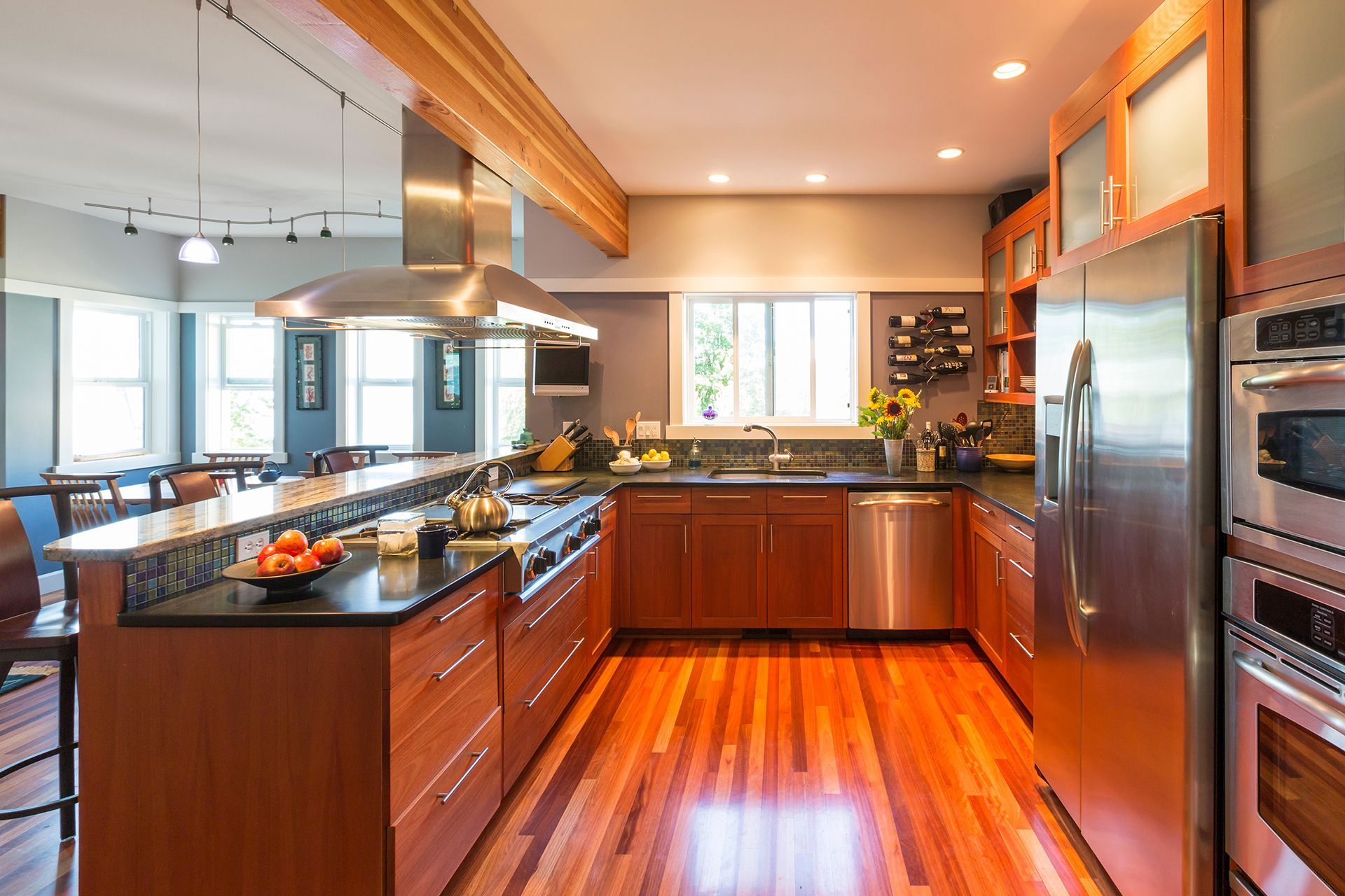 Modern kitchen with hardwood floors, wooden cabinets, stainless steel appliances, and a granite countertop. Modern kitchen with hardwood floors, wooden cabinets, stainless steel appliances, and a granite countertop.