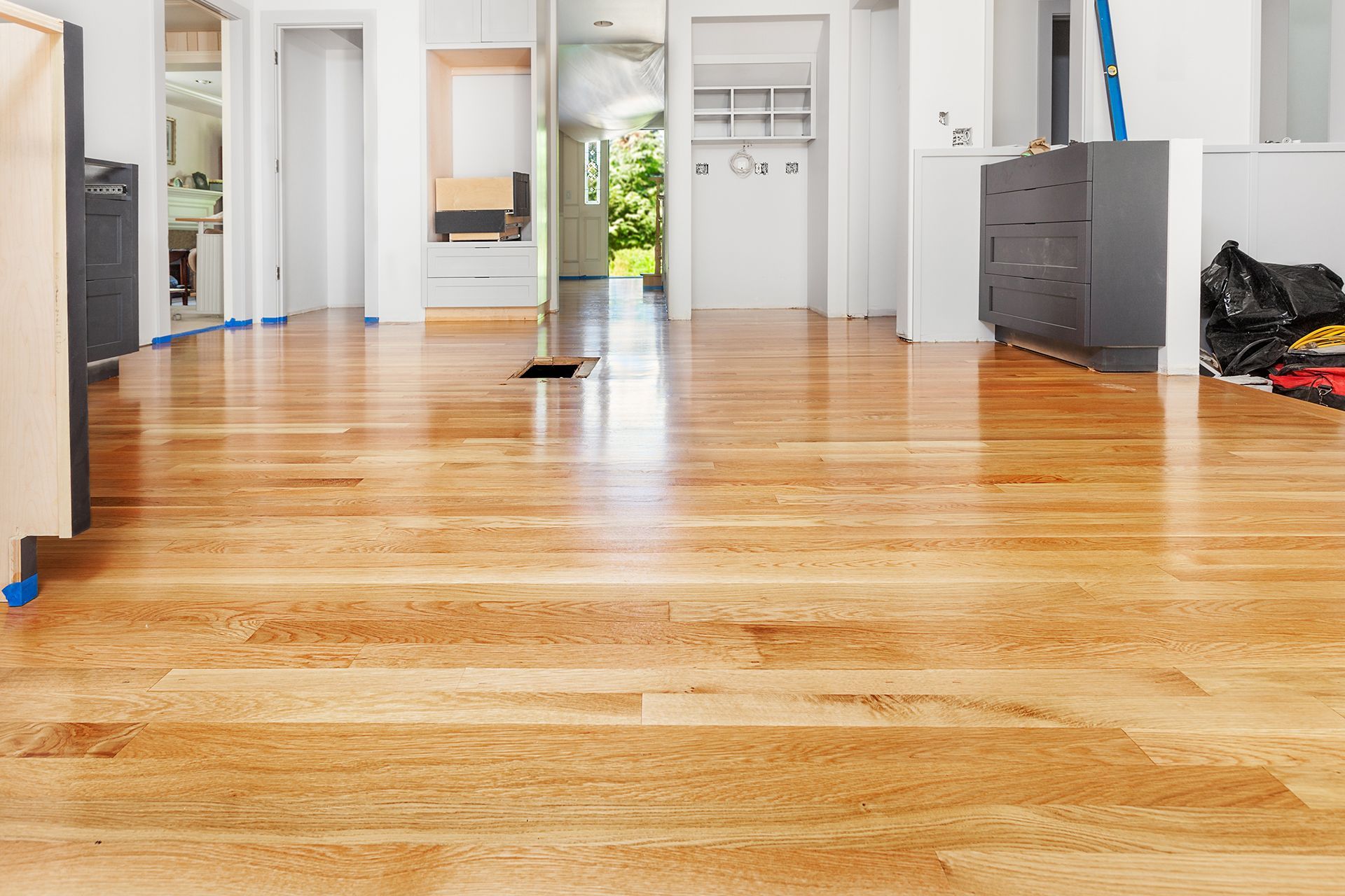Hardwood floors in a renovated home. Open space with cabinets, doorways, and natural light. Hardwood floors in a renovated home. Open space with cabinets, doorways, and natural light.