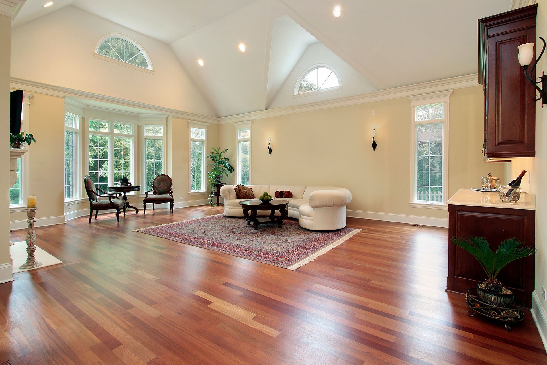 Spacious living room with hardwood floors, a white couch, and large windows. Spacious living room with hardwood floors, a white couch, and large windows.