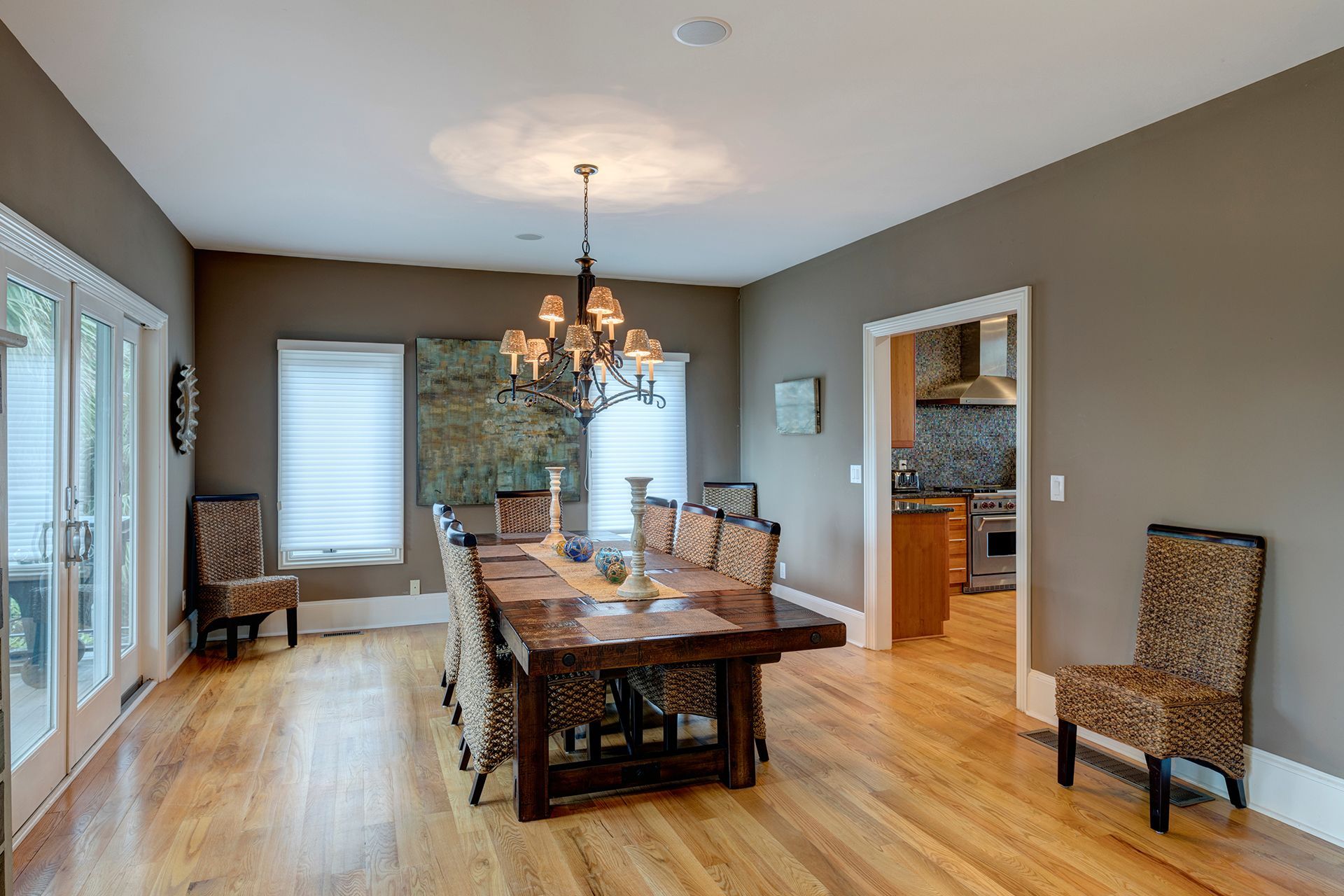 Dining room with wooden table, chairs, hardwood floors, and access to kitchen and outdoors. Dining room with wooden table, chairs, hardwood floors, and access to kitchen and outdoors.