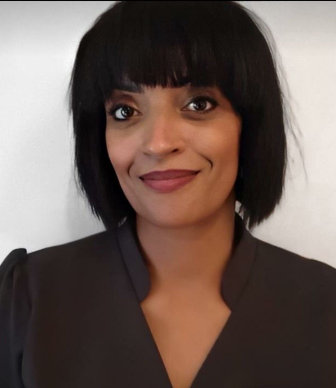 a woman with short black hair is smiling for the camera