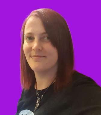 a woman with red hair is wearing a black shirt and a necklace .
