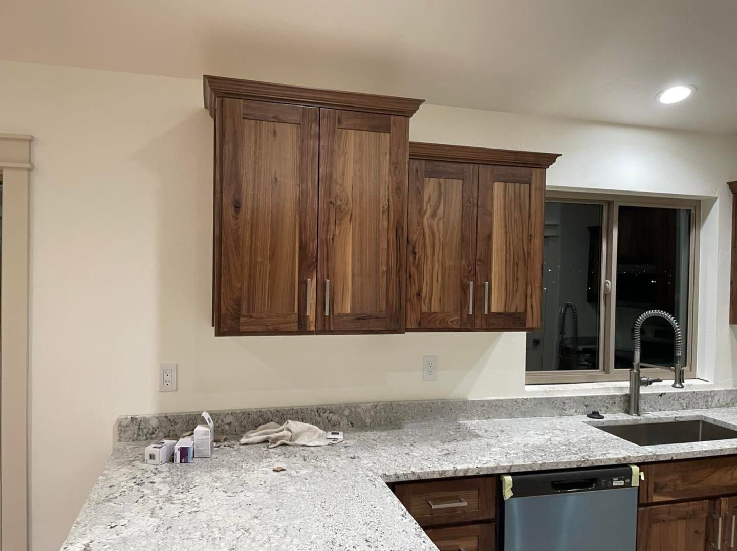 Kitchen with wood cabinets, granite countertops, sink, and a window over the counter.