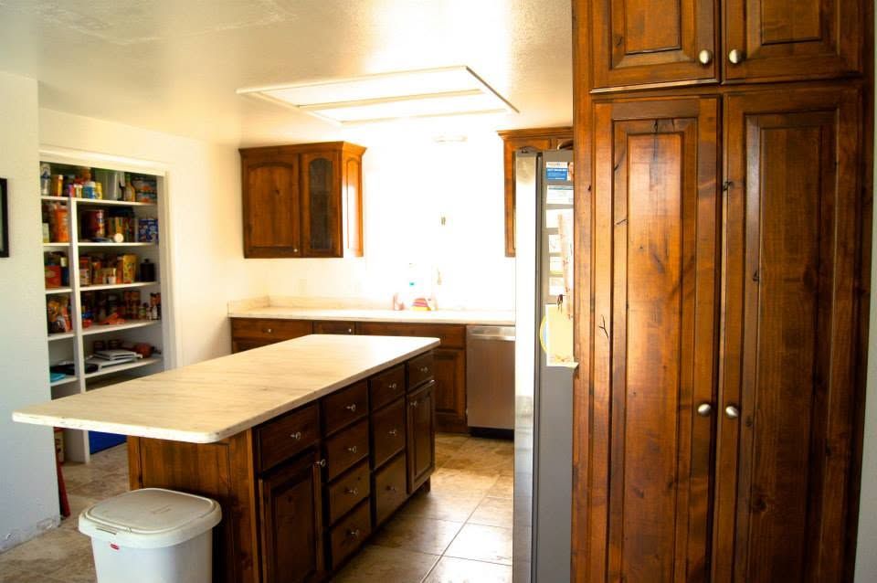 Bright kitchen with wooden cabinets, island countertop, and open pantry shelves