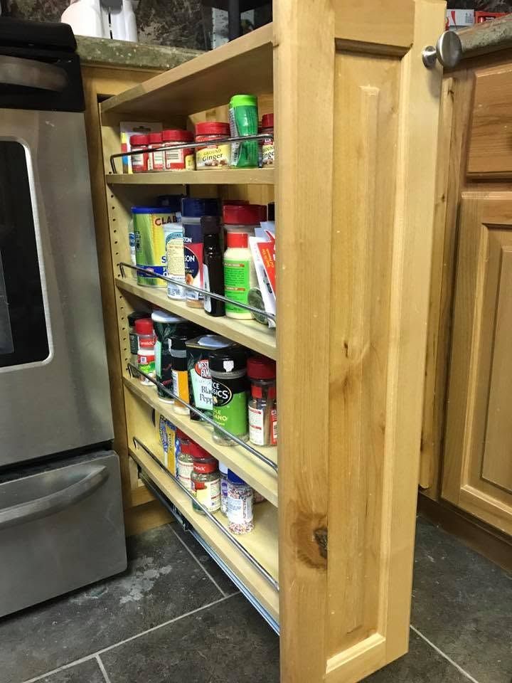 Pantry cabinet with shelves of assorted canned and boxed food beside a stainless steel refrigerator.