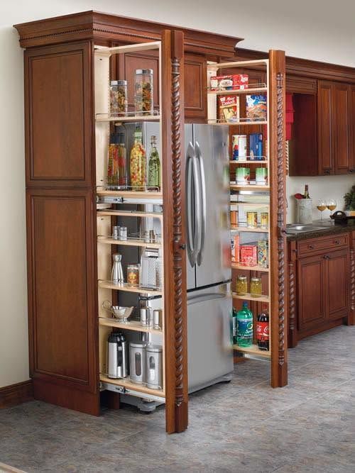 Open pantry cabinet built around a stainless steel refrigerator in a kitchen
