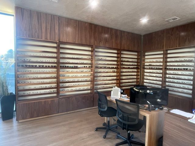 Wood-paneled room with wall-mounted display shelves, a desk, and two chairs