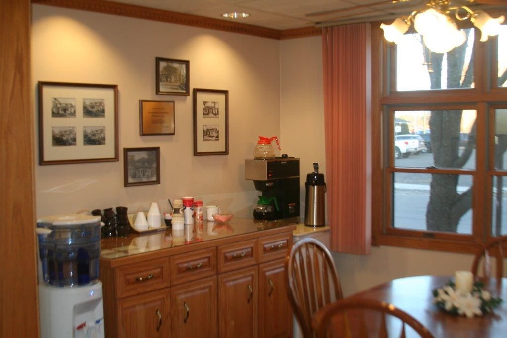 Coffee station with framed pictures on the wall, water cooler, and a window.
