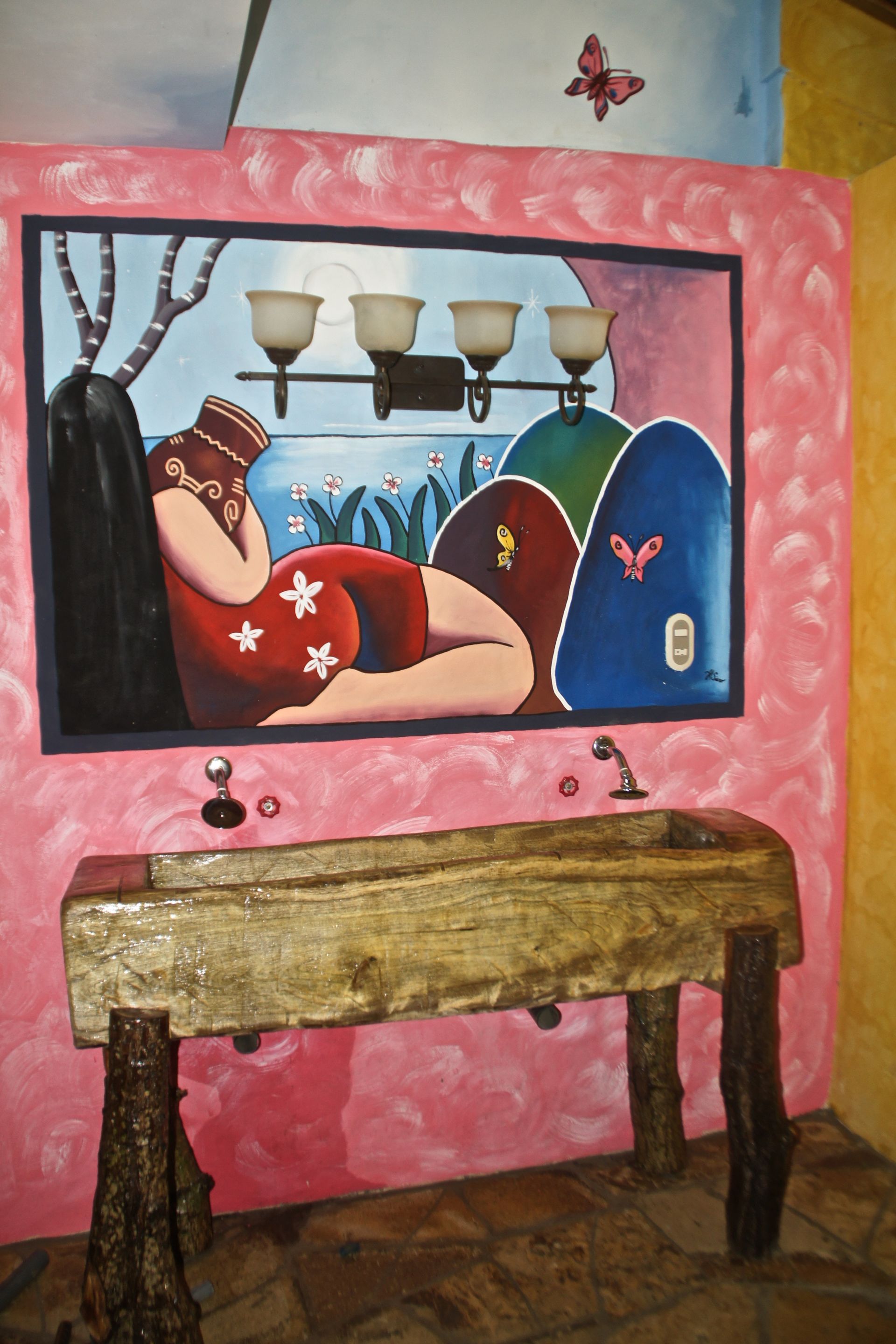 Painting of a reclining person in a blue and red interior scene above a rustic wooden table