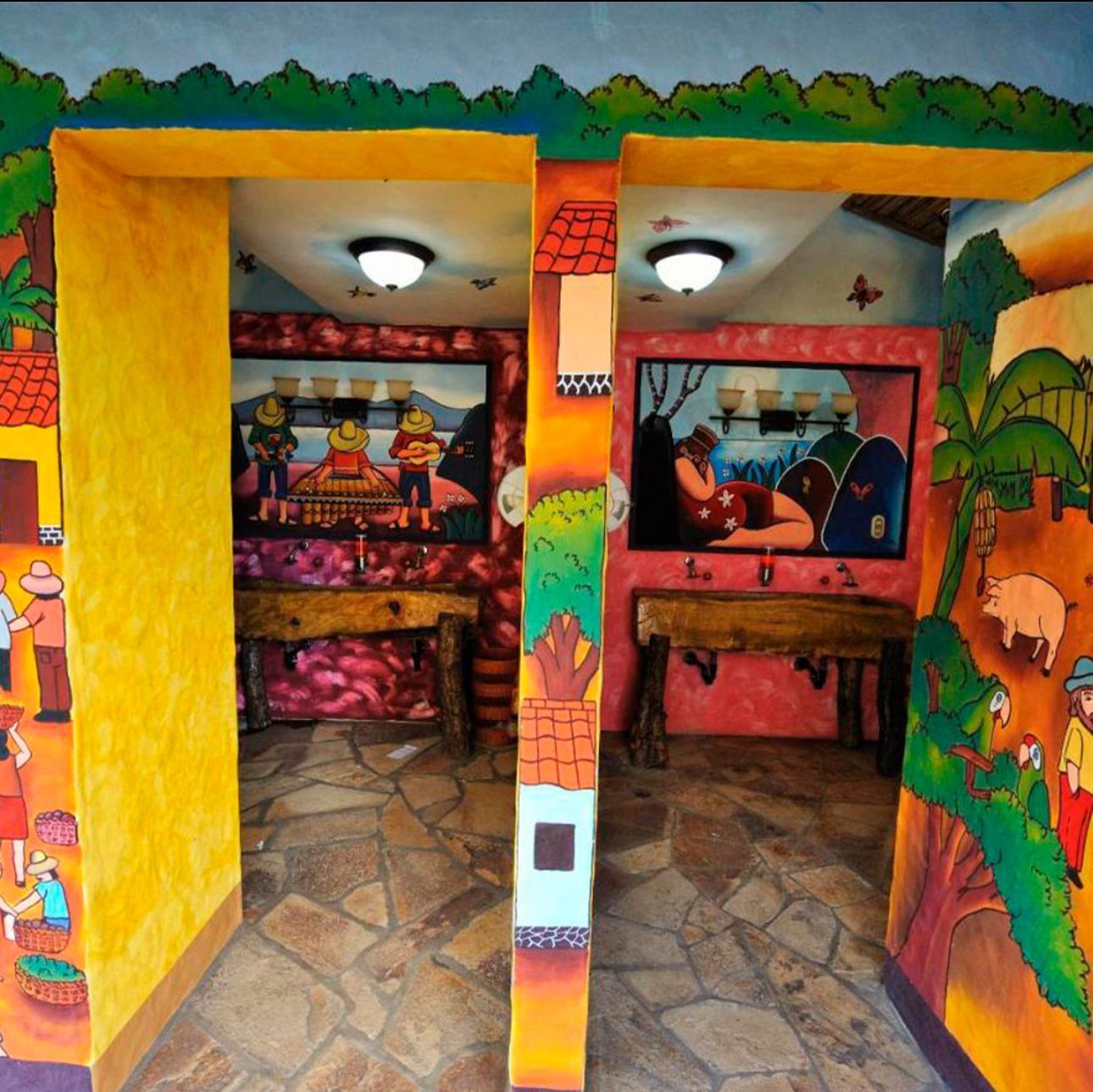 Colorful painted mural on a building entrance with two open stalls and stone floor