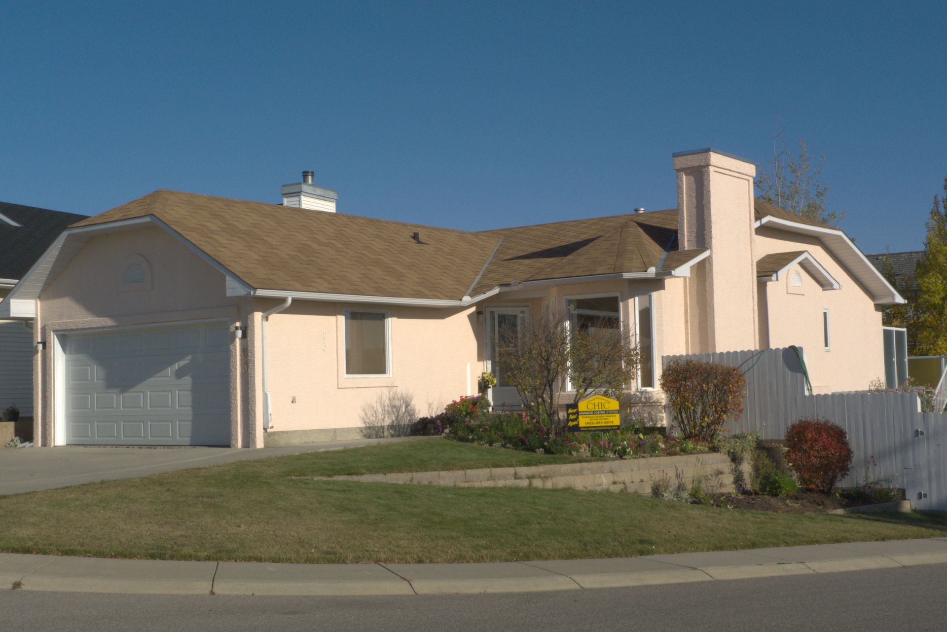 A house with a brown roof has a yellow sign in front of it