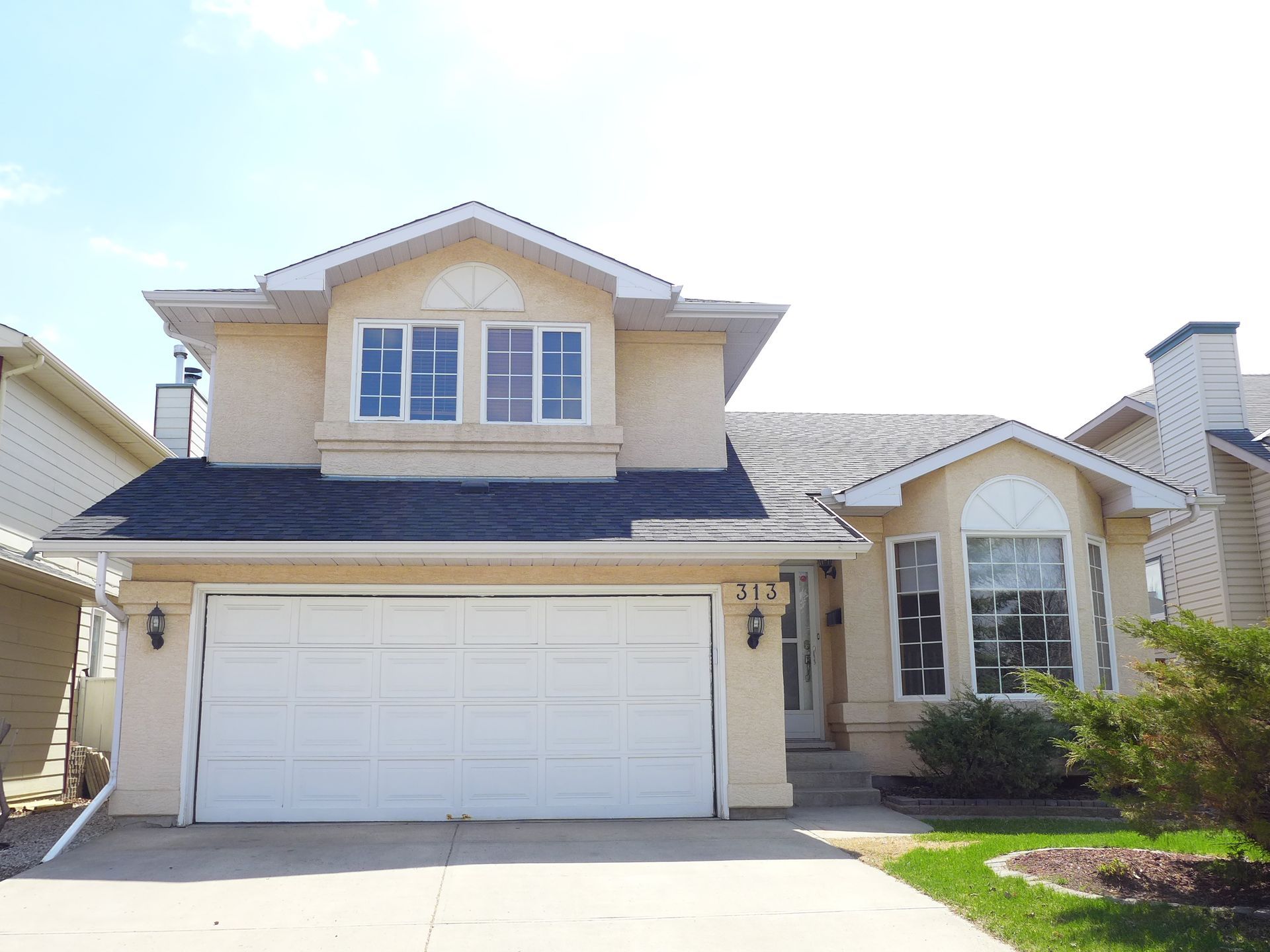 The front of a house with a white garage door