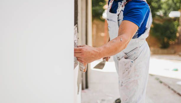 A person is plastering a wall with a spatula.