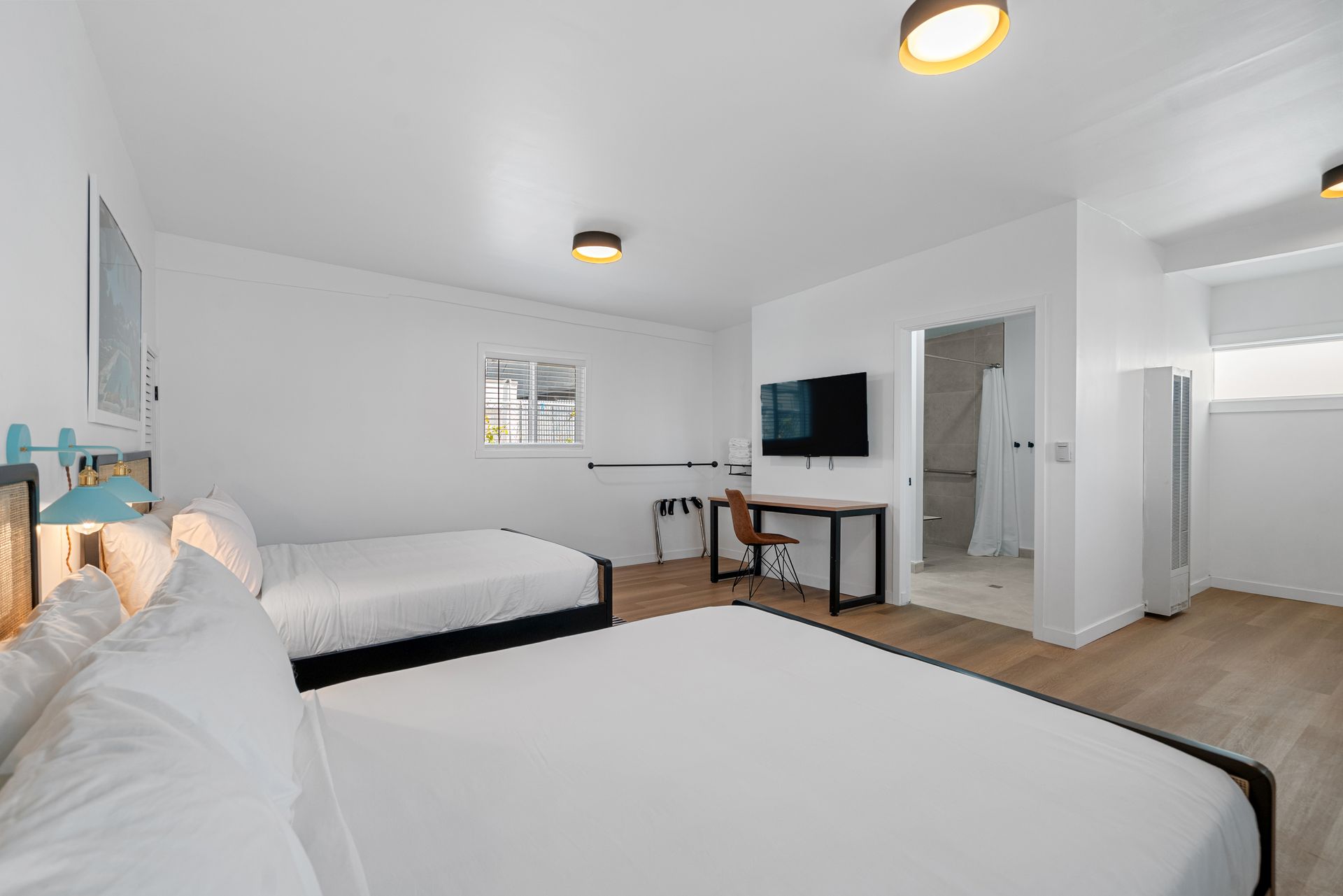 A hotel room with two beds , a desk and a television.