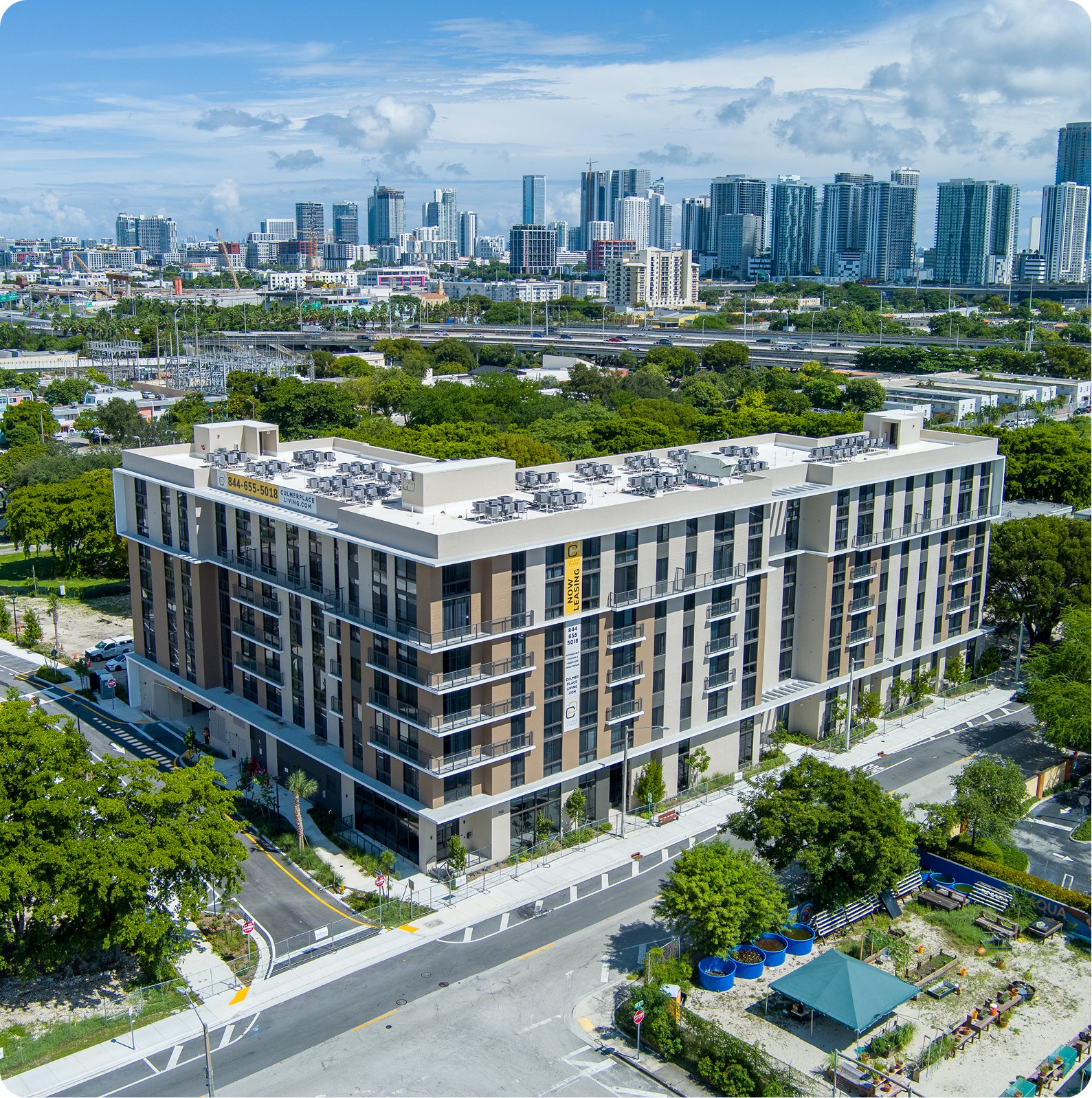 Modern office building with a city skyline in the background under a blue sky