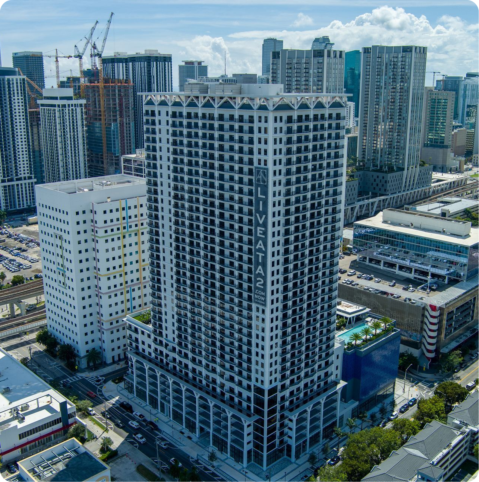Aerial view of a high-rise city building under construction, surrounded by modern towers.