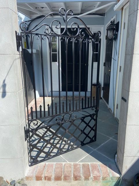 Custom ornamental wrought iron fence and gate at a Charleston-style property