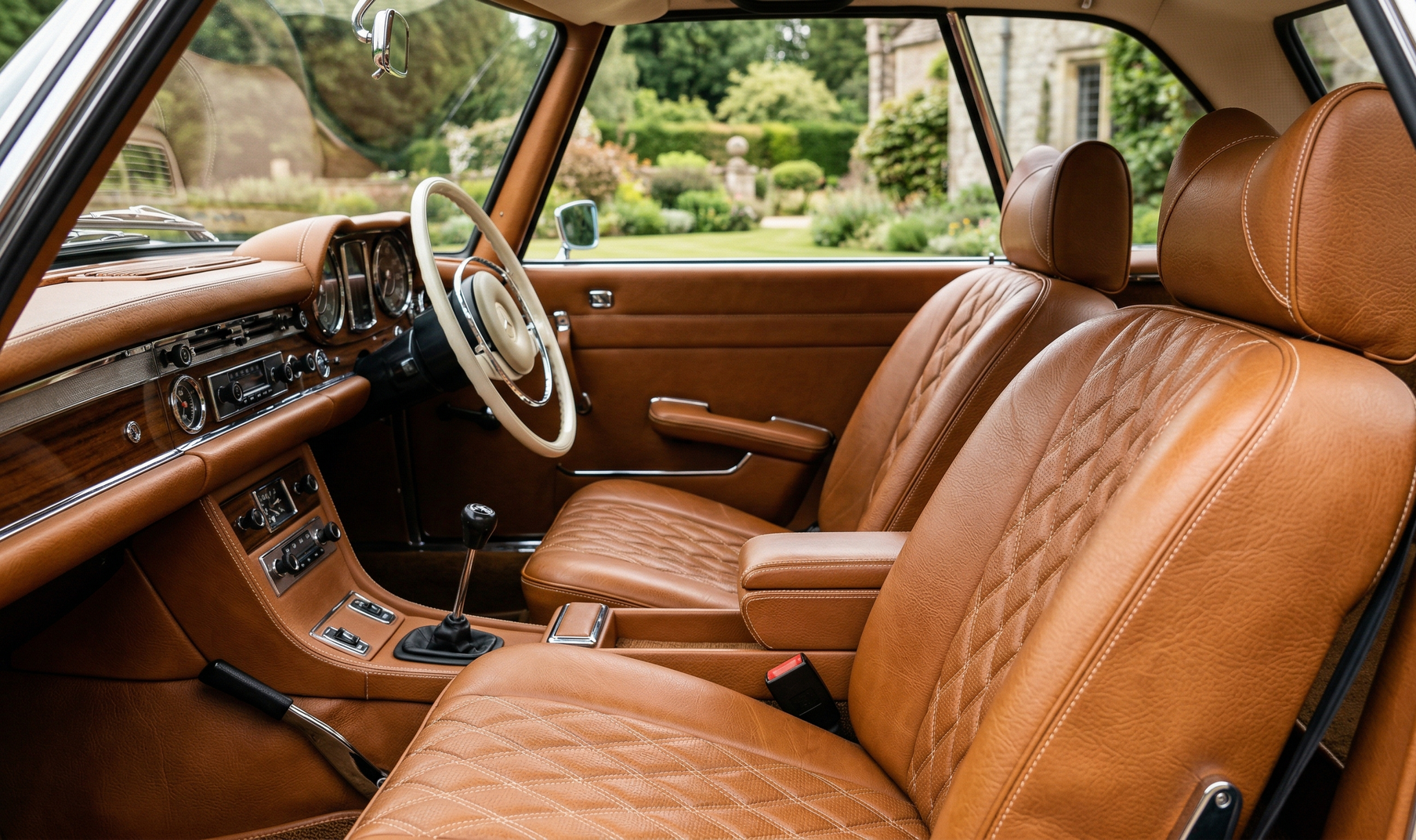 The interior of a classic car featuring dark blue upholstered seats and a vintage steering wheel.